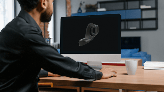 A man examines prostate massager design on monitor , highlighting ergonomic and cutting-edge wellness technology.